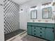 Modern bathroom features a glass shower with black and white tile and double vanity with storage at 605 W Holt St, Mebane, NC 27302