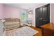 Charming Bedroom with hardwood floors, black doors, gold crib, and pink walls at 605 W Holt St, Mebane, NC 27302