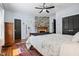 Bedroom with stone fireplace, hardwood floors, ceiling fan, and ensuite bathroom at 605 W Holt St, Mebane, NC 27302