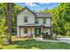 Charming two-story home with a metal roof, welcoming front porch, and freshly landscaped yard at 605 W Holt St, Mebane, NC 27302