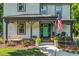 Inviting front porch with seating, landscaping, and a charming teal-colored front door at 605 W Holt St, Mebane, NC 27302