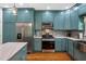 Open kitchen with stainless steel appliances, blue cabinetry, and a marble countertop at 605 W Holt St, Mebane, NC 27302