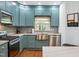 Beautiful kitchen with custom blue cabinets, stainless steel appliances, and a farmhouse sink at 605 W Holt St, Mebane, NC 27302