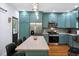 Open kitchen with island, stainless steel appliances, and blue cabinets with marble countertops at 605 W Holt St, Mebane, NC 27302
