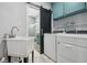 Functional laundry room includes a sink, cabinetry, washer, dryer, and barn door to bathroom at 605 W Holt St, Mebane, NC 27302