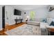 Inviting living room features wood floors, a sectional sofa, and a mounted television at 605 W Holt St, Mebane, NC 27302