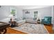Cozy living room with hardwood floors, neutral sectional sofa, and large patterned rug at 605 W Holt St, Mebane, NC 27302