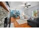 Cozy living room featuring a stone fireplace, hardwood floors, and open access to the kitchen at 605 W Holt St, Mebane, NC 27302
