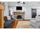 Comfortable living room featuring hardwood floors, a stone fireplace, and a mounted television at 605 W Holt St, Mebane, NC 27302