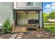 Charming covered patio area with steps down to mulch ground and natural privacy fence at 605 W Holt St, Mebane, NC 27302