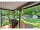 Covered patio with grilling area overlooking the fenced yard, chicken coop, and shed at 605 W Holt St, Mebane, NC 27302