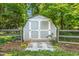 Outdoor storage shed surrounded by a wooden fence, landscaping and mulch at 605 W Holt St, Mebane, NC 27302