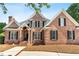 Charming brick home featuring a well-manicured lawn, black shutters, and an inviting covered front porch at 619 Baybush Dr, Raleigh, NC 27615