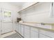 Well-lit laundry room with ample counter space, sink, and storage cabinets plus access to the exterior at 619 Baybush Dr, Raleigh, NC 27615