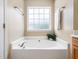 Relaxing bathroom featuring a large soaking tub with a frosted window and a plant at 6228 Saybrooke Dr, Raleigh, NC 27604