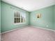 Cozy bedroom with natural light from the window, neutral carpet, and light green walls at 6228 Saybrooke Dr, Raleigh, NC 27604