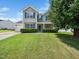 Charming two-story home featuring a well-manicured lawn and welcoming curb appeal with mature tree and tasteful landscaping at 6228 Saybrooke Dr, Raleigh, NC 27604