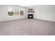 Cozy living room features a fireplace and large windows allowing for ample natural light and neutral carpet at 6228 Saybrooke Dr, Raleigh, NC 27604