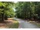 Scenic view of a paved walking trail winding through a lush, green forest at 6228 Saybrooke Dr, Raleigh, NC 27604