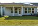 The backyard features a well-maintained lawn, covered patio, and exterior of the home with gray siding at 660 Still Willow Ln, Wendell, NC 27591