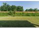 Lush green backyard with a well-maintained lawn, a wooden fence, and mature trees at 660 Still Willow Ln, Wendell, NC 27591
