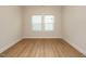Spacious bedroom featuring beautiful hardwood floors and a large window, providing ample natural light at 660 Still Willow Ln, Wendell, NC 27591