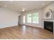 Bright living room featuring hardwood floors, fireplace, and a ceiling fan, with access to the backyard and another room at 660 Still Willow Ln, Wendell, NC 27591
