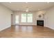 Open living room featuring a ceiling fan, a fireplace, hardwood floors, and access to the backyard at 660 Still Willow Ln, Wendell, NC 27591