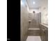 Walk-in shower featuring gray tiling, built-in bench, showerhead, and a glass enclosure at 660 Still Willow Ln, Wendell, NC 27591