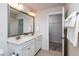 Bright bathroom featuring a double sink vanity with large mirror and open doorway to walk-in closet at 7809 Lillyhurst Dr, Raleigh, NC 27612