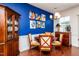 Dining room showcasing a wooden table with chairs, a cobalt blue accent wall with rooster art, and hardwood floors at 7809 Lillyhurst Dr, Raleigh, NC 27612