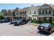 View of townhome exteriors with multiple parked cars at 7809 Lillyhurst Dr, Raleigh, NC 27612