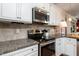 Close up of a modern kitchen with granite countertops, stainless steel appliances, and white cabinets at 7809 Lillyhurst Dr, Raleigh, NC 27612