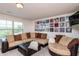 Bright living room featuring a plush sectional sofa, desk, and decorative record albums at 7809 Lillyhurst Dr, Raleigh, NC 27612