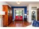 Bright living room featuring hardwood floors, a decorative hutch, and seating area with a vibrant blue accent wall at 7809 Lillyhurst Dr, Raleigh, NC 27612