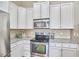 Kitchen with white cabinets, granite countertops, and stainless steel appliances at 808 Historian St, Raleigh, NC 27603