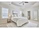 Comfortable main bedroom with a tray ceiling, windows, and adjoining bathroom at 808 Historian St, Raleigh, NC 27603