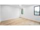 Minimalist bedroom with hardwood floors and natural light from two windows at 810 Culpepper Ln, Raleigh, NC 27610