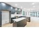 Bright, open kitchen featuring dark blue cabinets, white countertops, and stainless steel appliances, open to living area at 810 Culpepper Ln, Raleigh, NC 27610