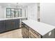 Well-lit kitchen with a double island layout, stainless steel appliances, and dark blue cabinetry at 810 Culpepper Ln, Raleigh, NC 27610