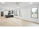 Spacious living room with light wood floors, black-framed windows, and an open floor plan at 810 Culpepper Ln, Raleigh, NC 27610
