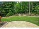 Lush backyard with stone patio, manicured landscaping, and seating area at 90 Weatherly Dr, Franklinton, NC 27525