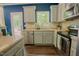 Modern kitchen featuring stainless steel dishwasher, appliances, and a backyard view at 90 Weatherly Dr, Franklinton, NC 27525