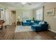 Spacious living room with hardwood floors, a comfortable blue sofa, and ample natural light creating a relaxing environment at 90 Weatherly Dr, Franklinton, NC 27525