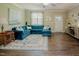 Bright living room with a blue sectional sofa, hardwood floors, and tasteful decor creating a comfortable and inviting space at 90 Weatherly Dr, Franklinton, NC 27525