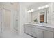 Bathroom vanity with double sinks, gold hardware, a large mirror and a marble tile shower at 907 Lake Beacon Way, Raleigh, NC 27606