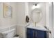 Charming half bathroom featuring wainscoting, stylish vanity, oval mirror and decorative accents at 907 Lake Beacon Way, Raleigh, NC 27606