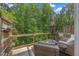Relaxing deck area with wicker furniture, an umbrella, and views of the surrounding greenery at 907 Lake Beacon Way, Raleigh, NC 27606