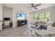 Bright living room with modern ceiling fan, desk, large windows, and comfortable sectional sofa at 907 Lake Beacon Way, Raleigh, NC 27606