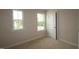 Bedroom featuring carpet, neutral walls, two windows, and a closet at 920 Montague Ave, Durham, NC 27703